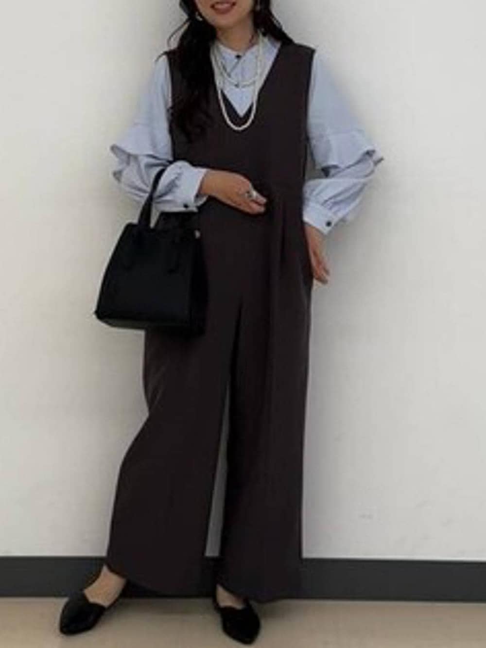 ブラック系のショルダーバッグ、ブラック系のパンプス、グレー系のセットアップを着用したレディースの冬コーディネートの6枚目の写真