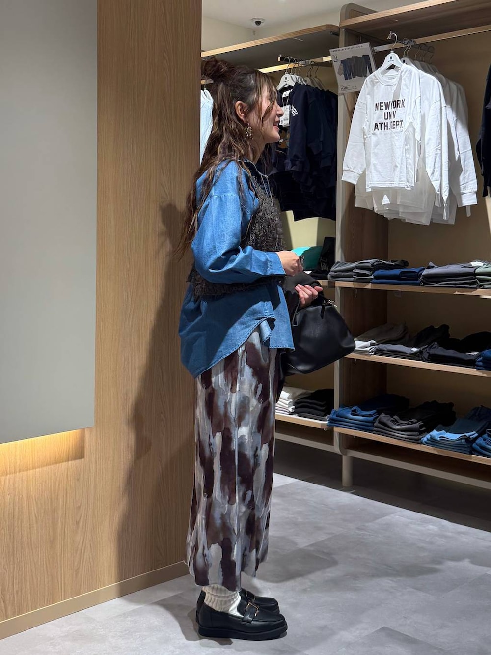 ブラック系のショルダーバッグ、ブラック系のローファー、ブルー系のシャツ/ブラウスを着用したレディースの春コーディネートの7枚目の写真