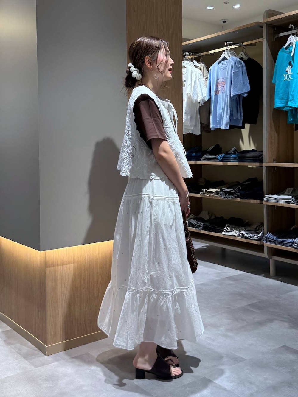 ホワイト系のベスト、ホワイト系のスカート、ブラウン系のTシャツ/カットソーを着用したレディースの夏コーディネートの3枚目の写真