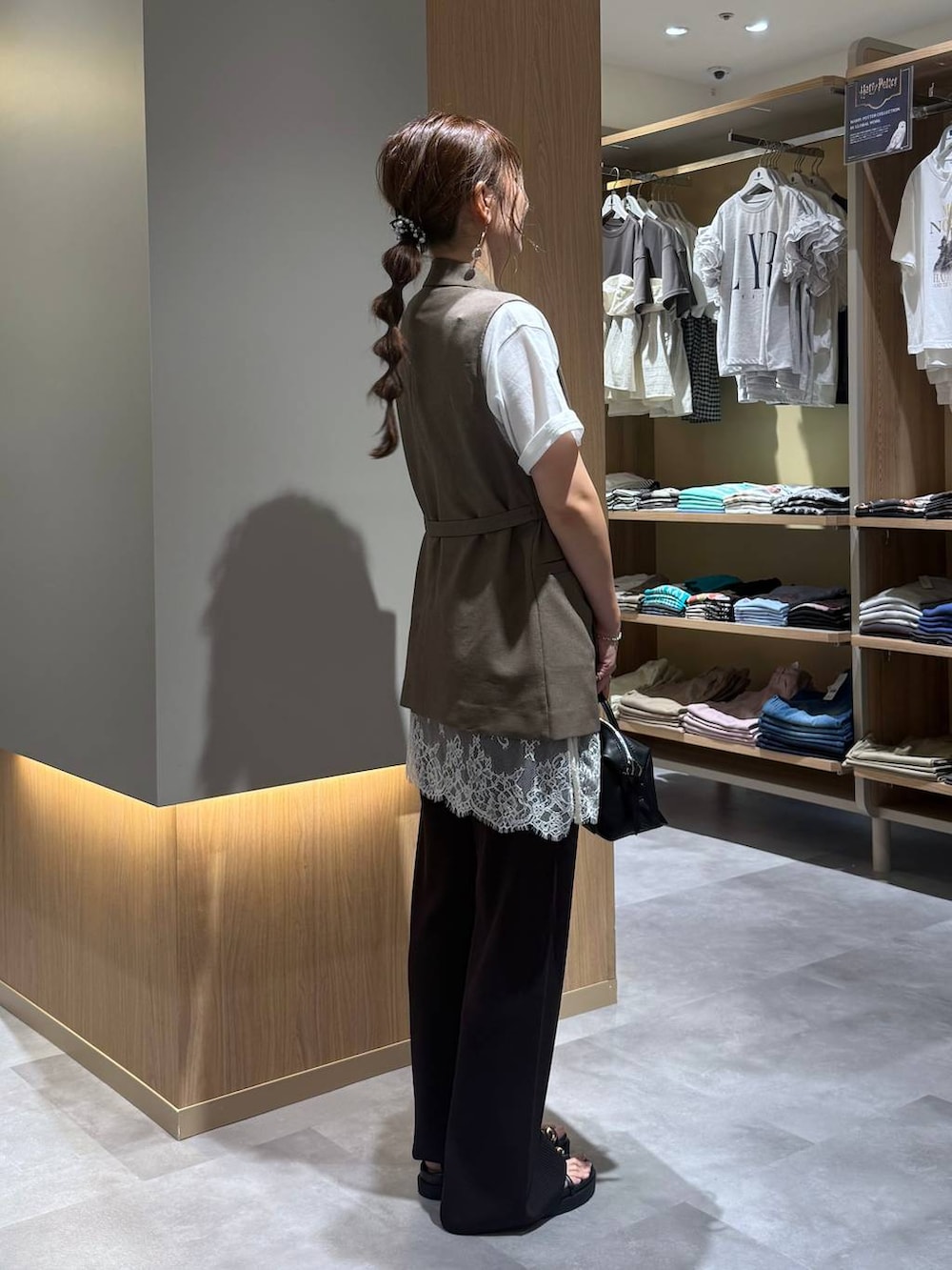 ブラウン系のベスト、ホワイト系のTシャツ/カットソー、ブラック系のボストンバッグを着用したレディースの夏コーディネートの3枚目の写真