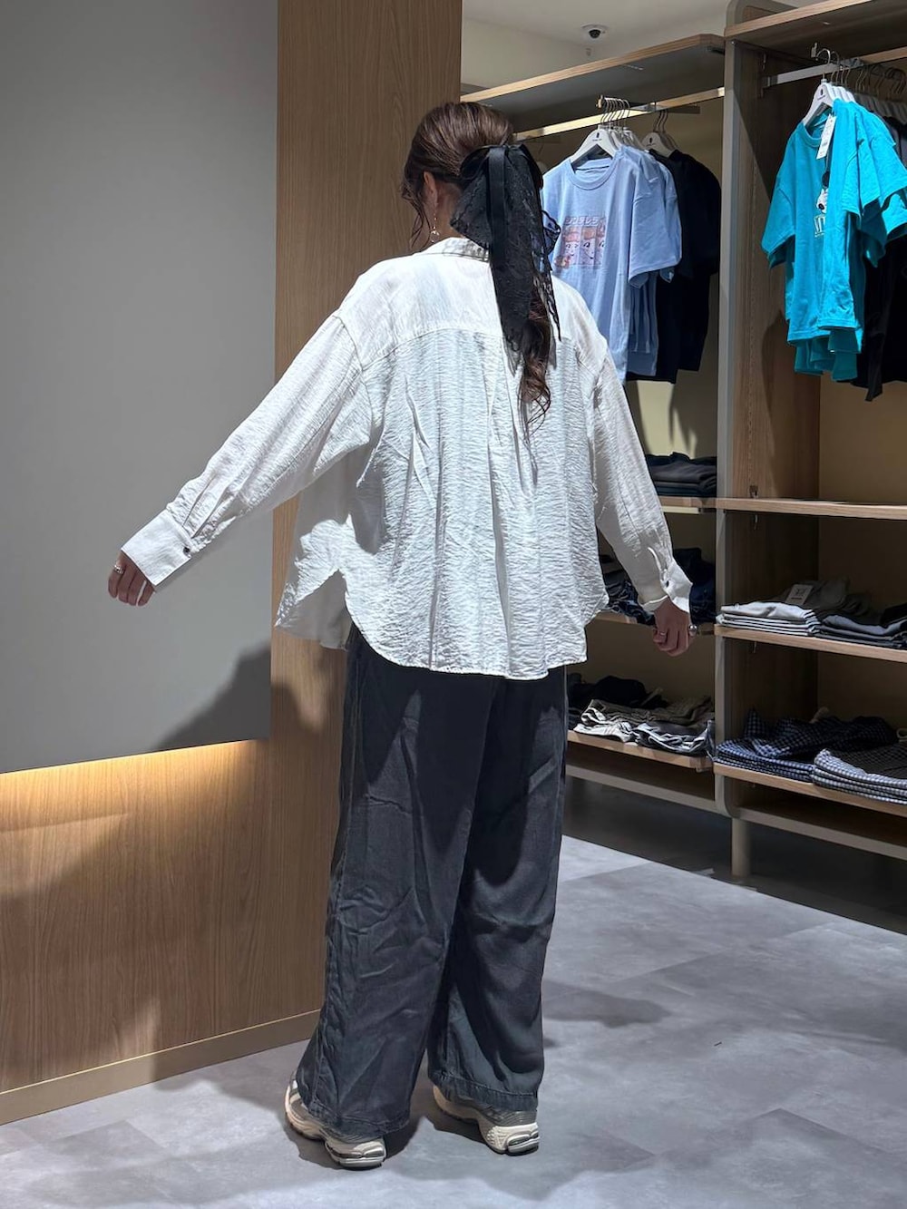 ベージュ系のパーカー、ブラック系のデニムパンツ、ホワイト系のシャツ/ブラウスを着用したレディースの春コーディネートの4枚目の写真
