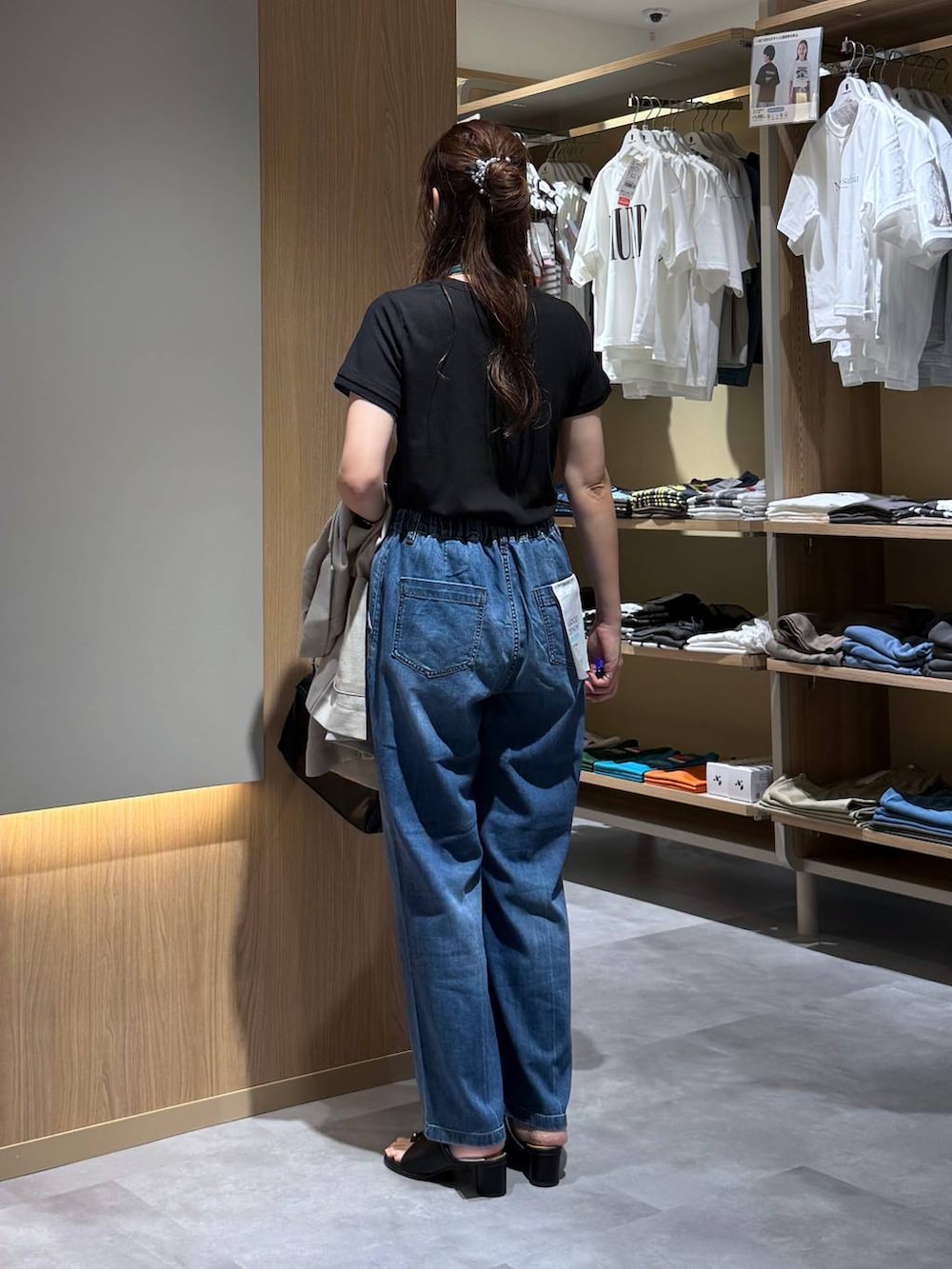 ブルー系のデニムパンツ、ベージュ系のテーラードジャケット、ブラック系のサンダルを着用したレディースの夏コーディネートの8枚目の写真