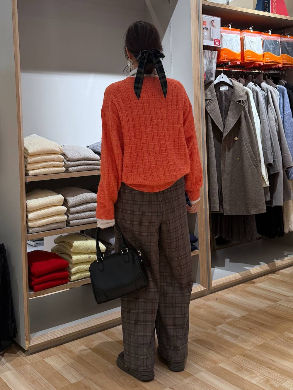 ベージュ系のダウンジャケット/コート、ホワイト系のTシャツ/カットソー、オレンジ系のニット/セーターを着用したレディースの春コーディネートの5枚目の写真