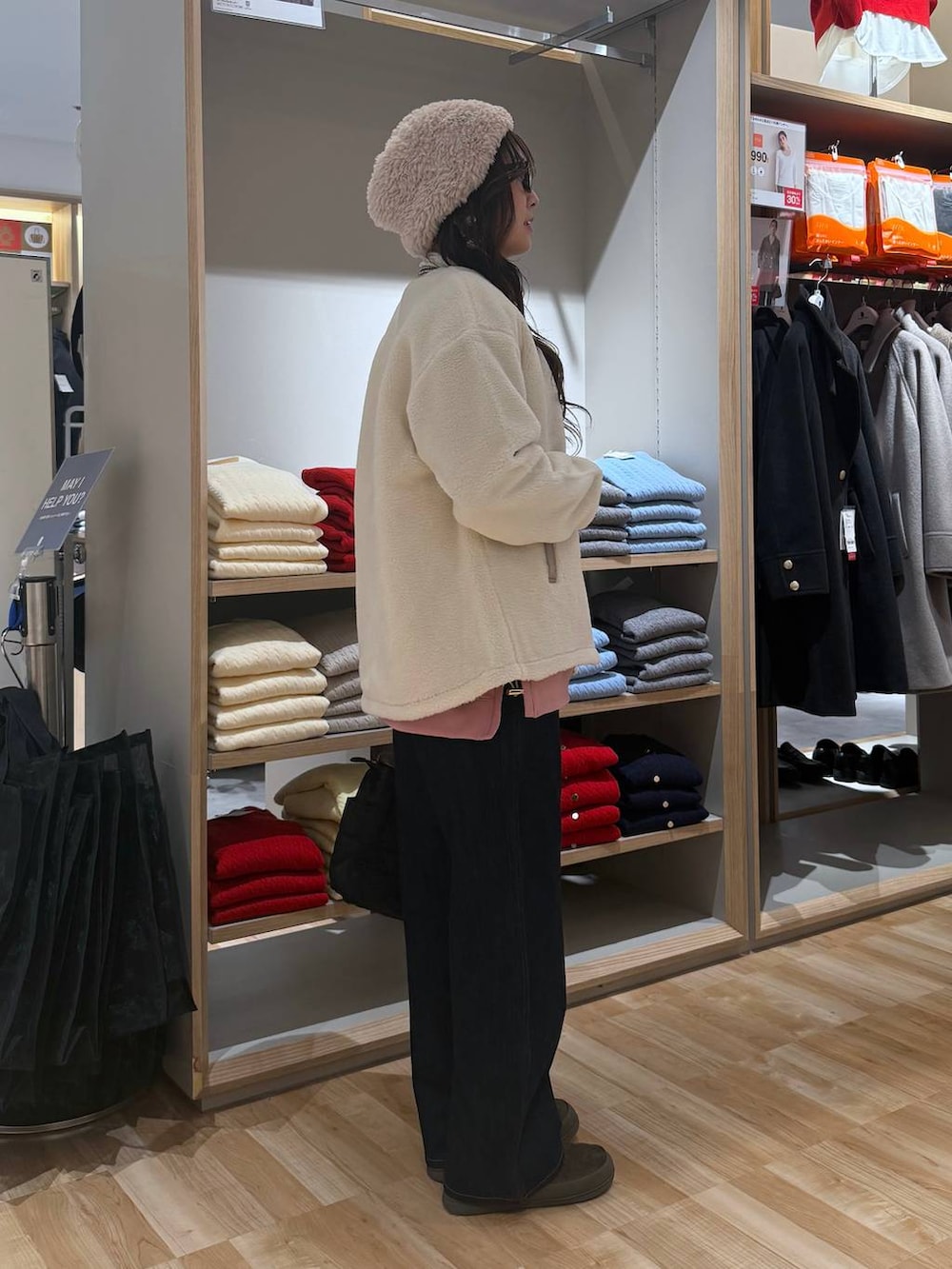 ブラック系のトートバッグ、ホワイト系のブルゾン、ブルー系のデニムパンツを着用したレディースの冬コーディネートの3枚目の写真