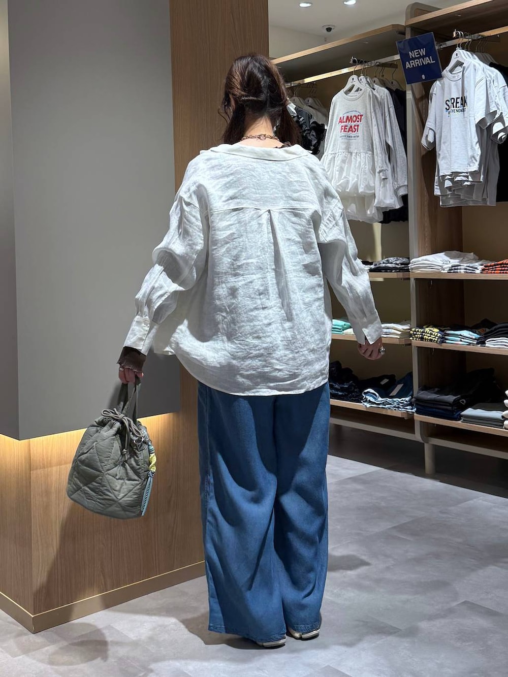 グリーン系のハンドバッグ、ホワイト系のシャツ/ブラウス、ブルー系のサロペット/オーバーオールを着用したレディースの春コーディネートの4枚目の写真