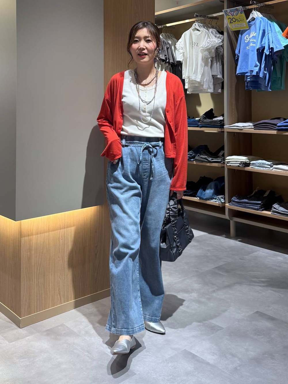 シルバー系のパンプス、グレー系のショルダーバッグ、ホワイト系のタンクトップを着用したレディースの春コーディネートの2枚目の写真