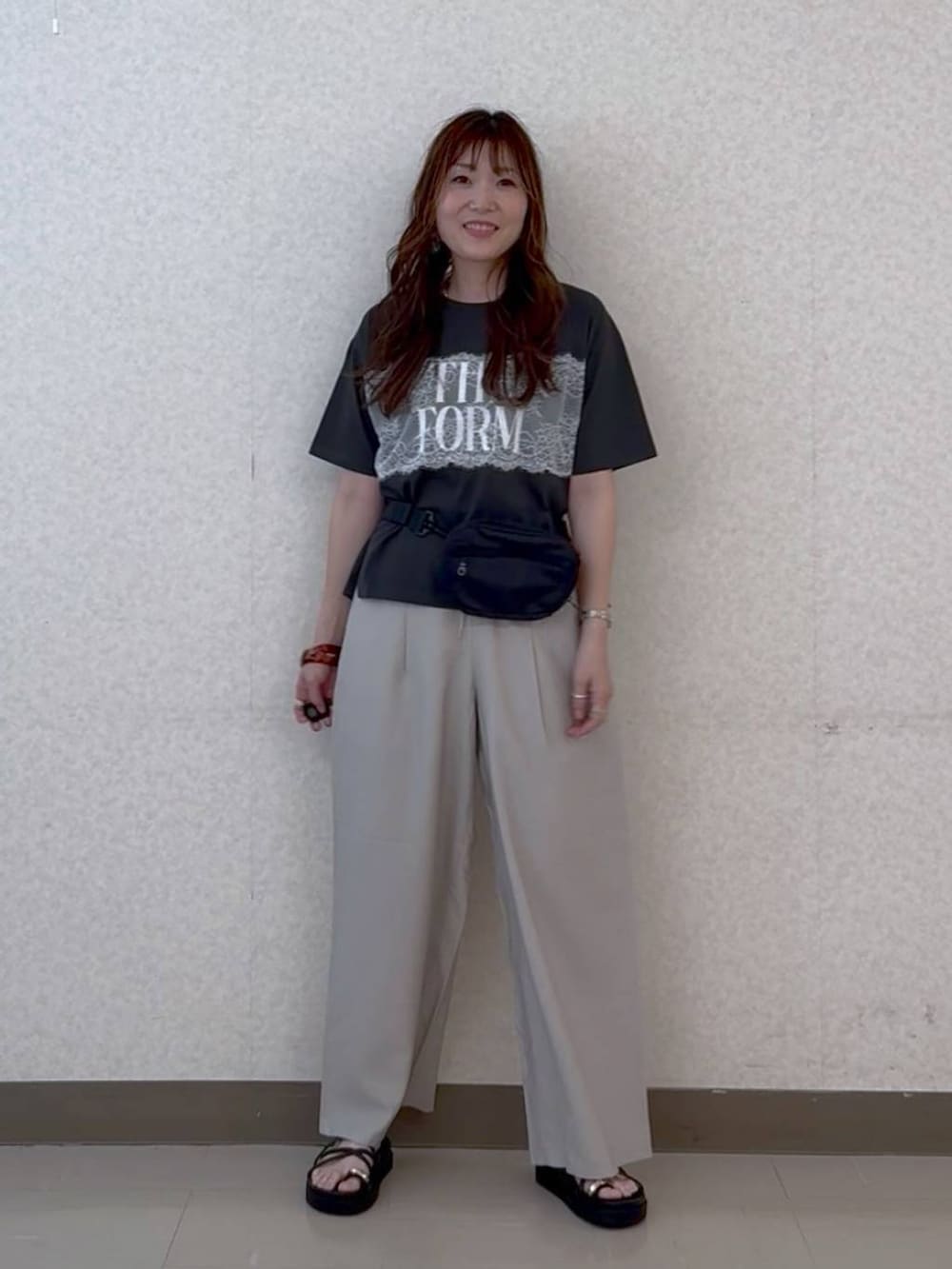 ベージュ系のその他パンツ、ブラック系のサンダル、ブラック系のボディバッグ/ウエストポーチを着用したレディースの夏コーディネートの2枚目の写真
