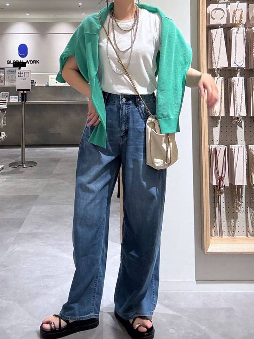 ブルー系のデニムパンツ、グリーン系のカーディガン/ボレロ、ベージュ系のボディバッグ/ウエストポーチを着用したレディースの夏コーディネートの6枚目の写真