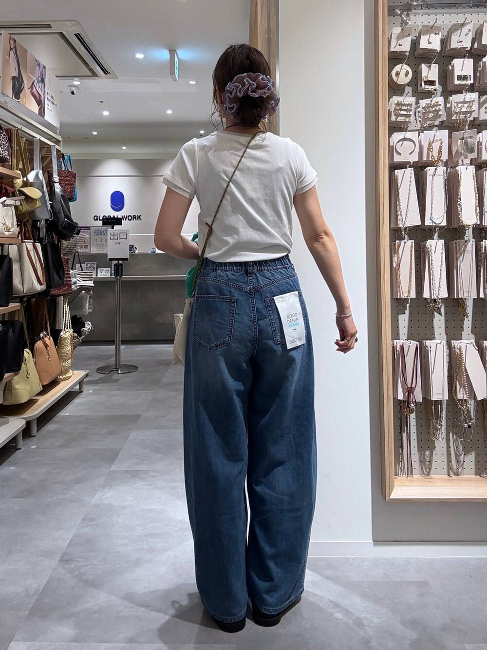 ブルー系のデニムパンツ、グリーン系のカーディガン/ボレロ、ベージュ系のボディバッグ/ウエストポーチを着用したレディースの夏コーディネートの5枚目の写真