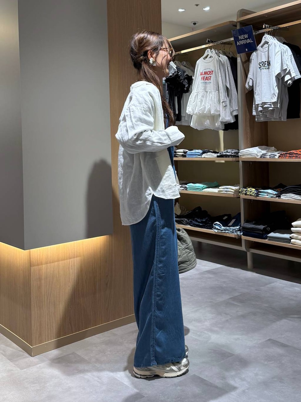 グリーン系のハンドバッグ、ホワイト系のシャツ/ブラウス、ブルー系のサロペット/オーバーオールを着用したレディースの春コーディネートの3枚目の写真