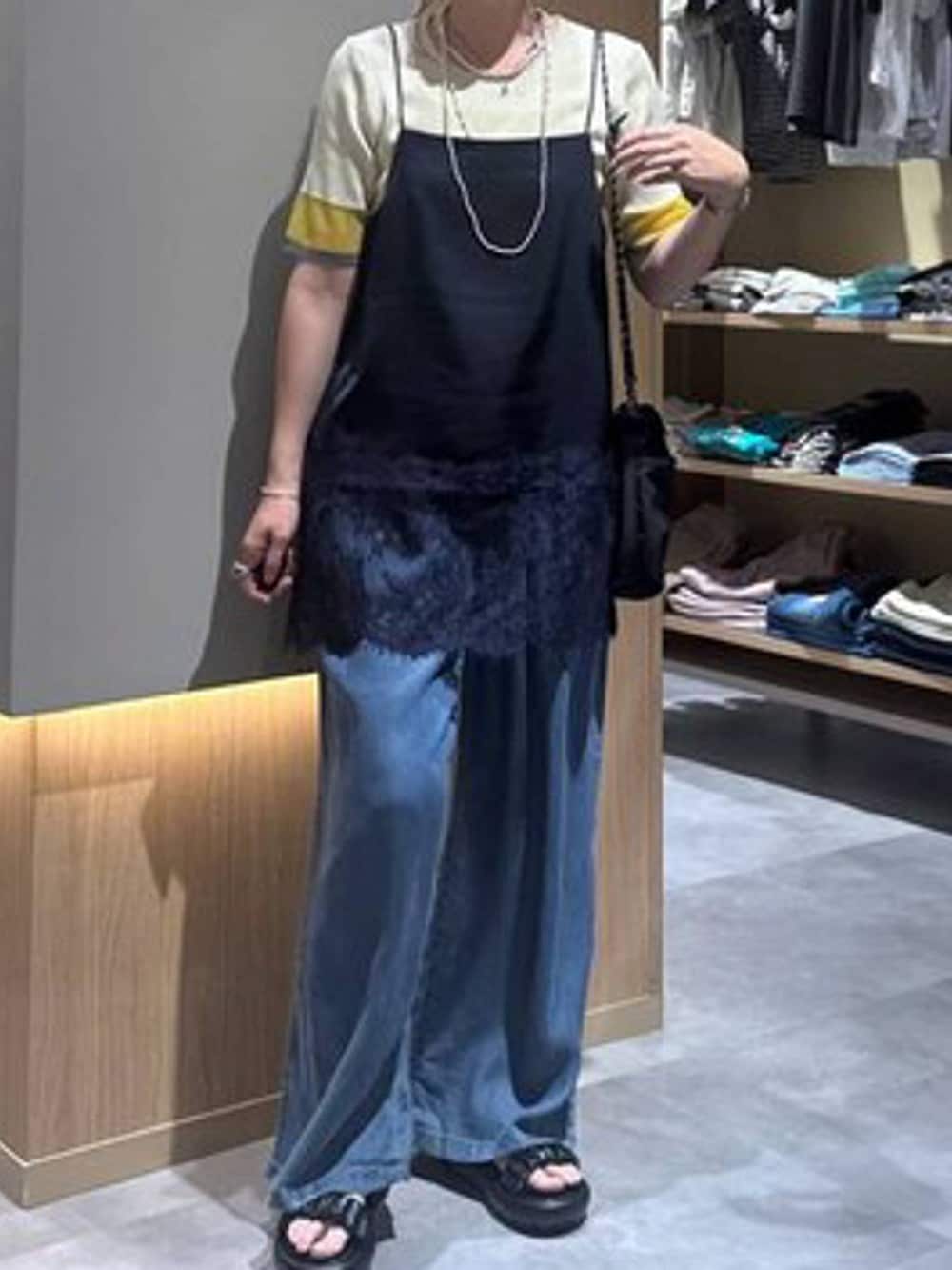 ブルー系のデニムパンツ、グレー系のボディバッグ/ウエストポーチ、イエロー系のニット/セーターを着用したレディースの夏コーディネートの6枚目の写真