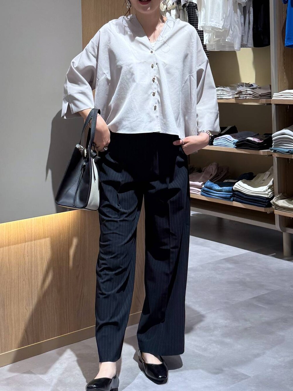 ブラック系のパンプス、ホワイト系のショルダーバッグ、ブルー系のその他パンツを着用したレディースの夏コーディネートの5枚目の写真