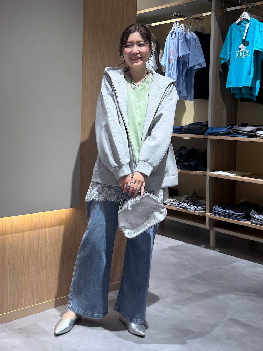 シルバー系のショルダーバッグ、シルバー系のパンプス、グリーン系のニット/セーターを着用したレディースの春コーディネートの6枚目の写真