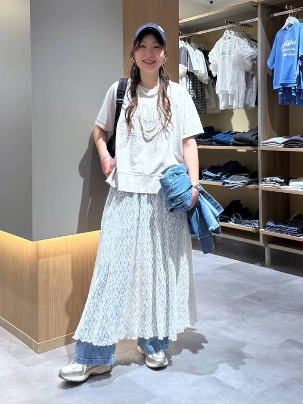 ブルー系のシャツ/ブラウス、ブルー系のデニムパンツ、ベージュ系のTシャツ/カットソーを着用したレディースの夏コーディネートの2枚目の写真