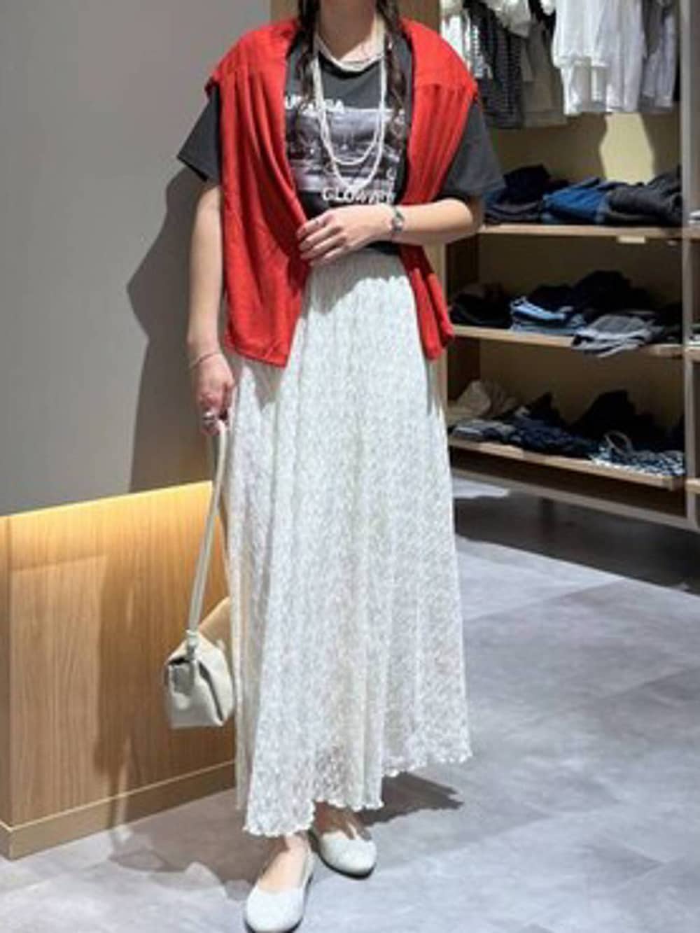 ベージュ系のショルダーバッグ、オレンジ系のカーディガン/ボレロ、グレー系のTシャツ/カットソーを着用したレディースの夏コーディネートの5枚目の写真