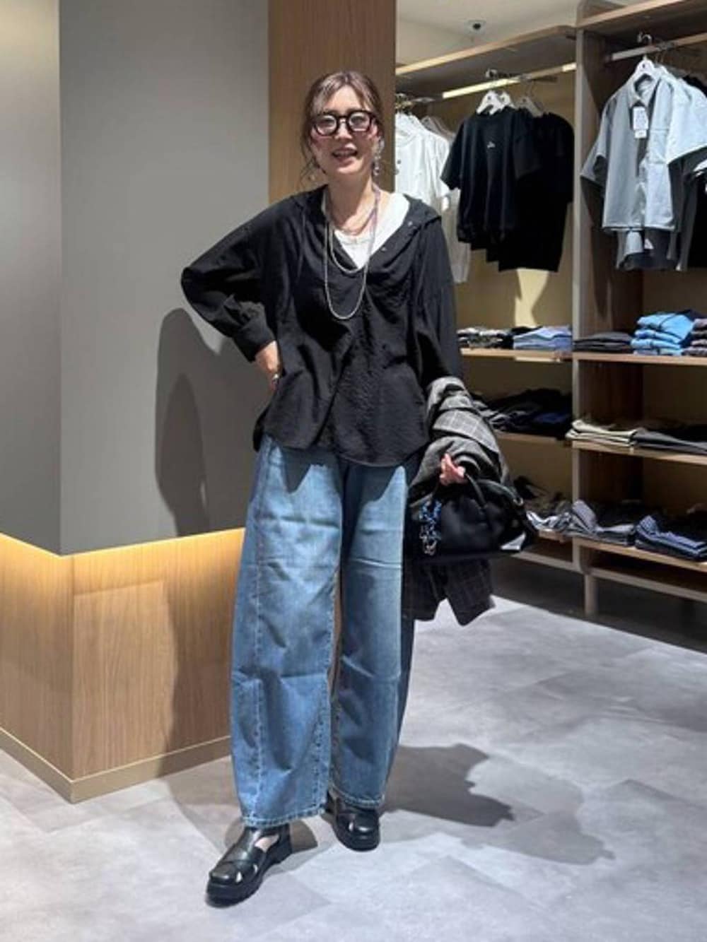 ブルー系のデニムパンツ、グレー系のテーラードジャケット、ホワイト系のタンクトップを着用したレディースの夏コーディネートの2枚目の写真