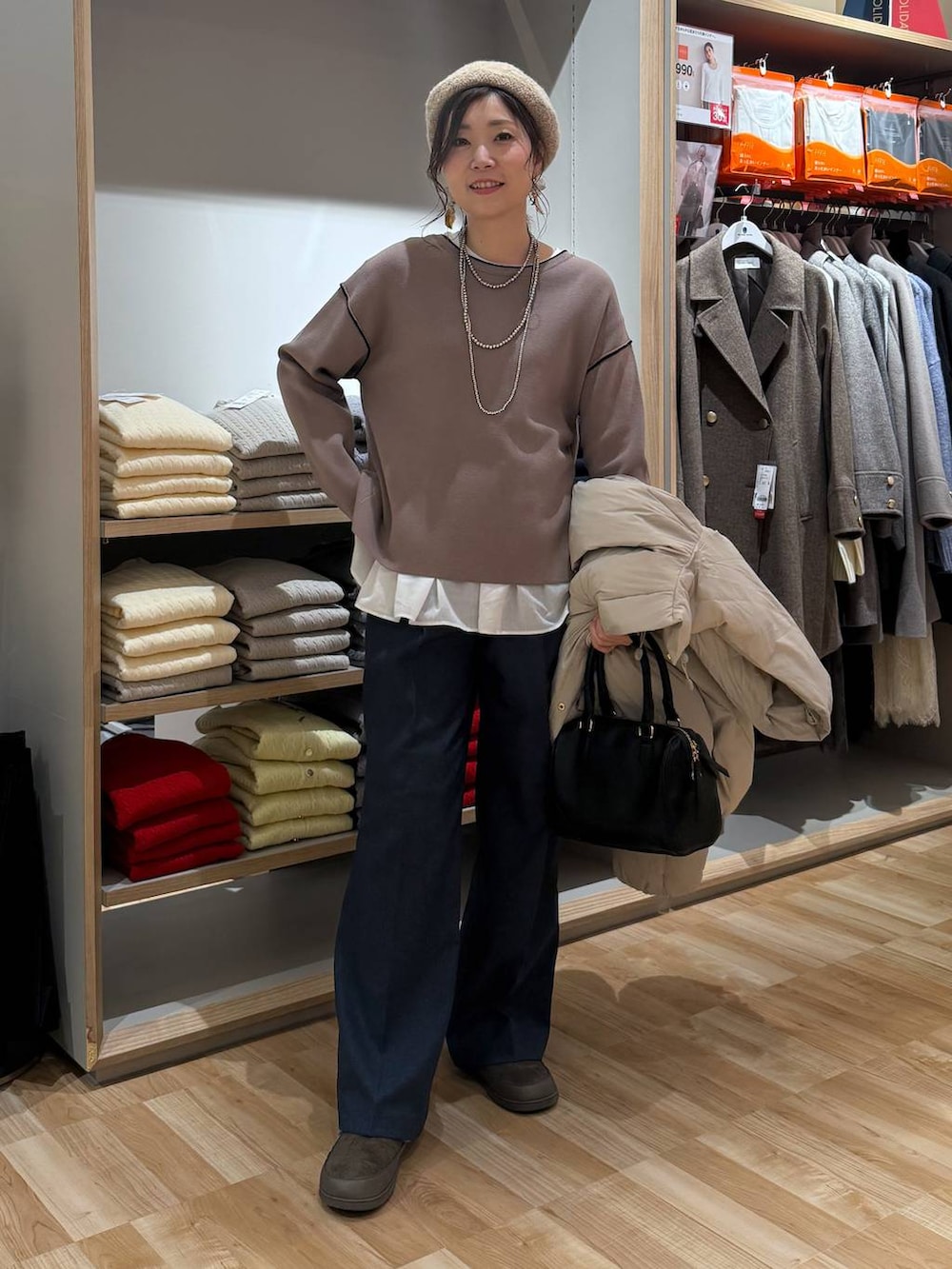 ベージュ系のダウンジャケット/コート、ブルー系のその他パンツ、ホワイト系のTシャツ/カットソーを着用したレディースの春コーディネートの2枚目の写真