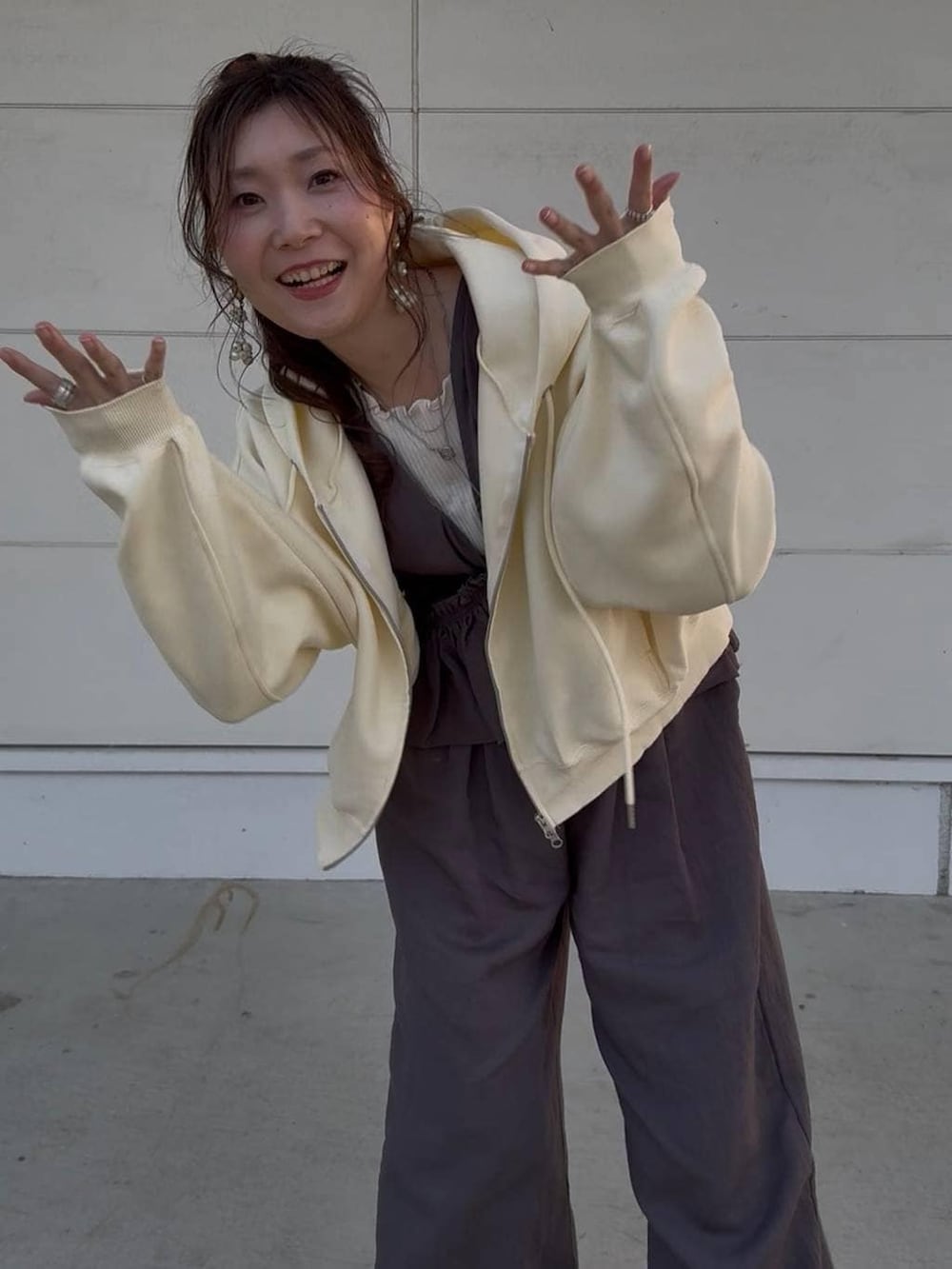 グレー系のサロペット/オーバーオール、イエロー系のパーカー、ホワイト系のTシャツ/カットソーを着用したレディースの春コーディネートの2枚目の写真