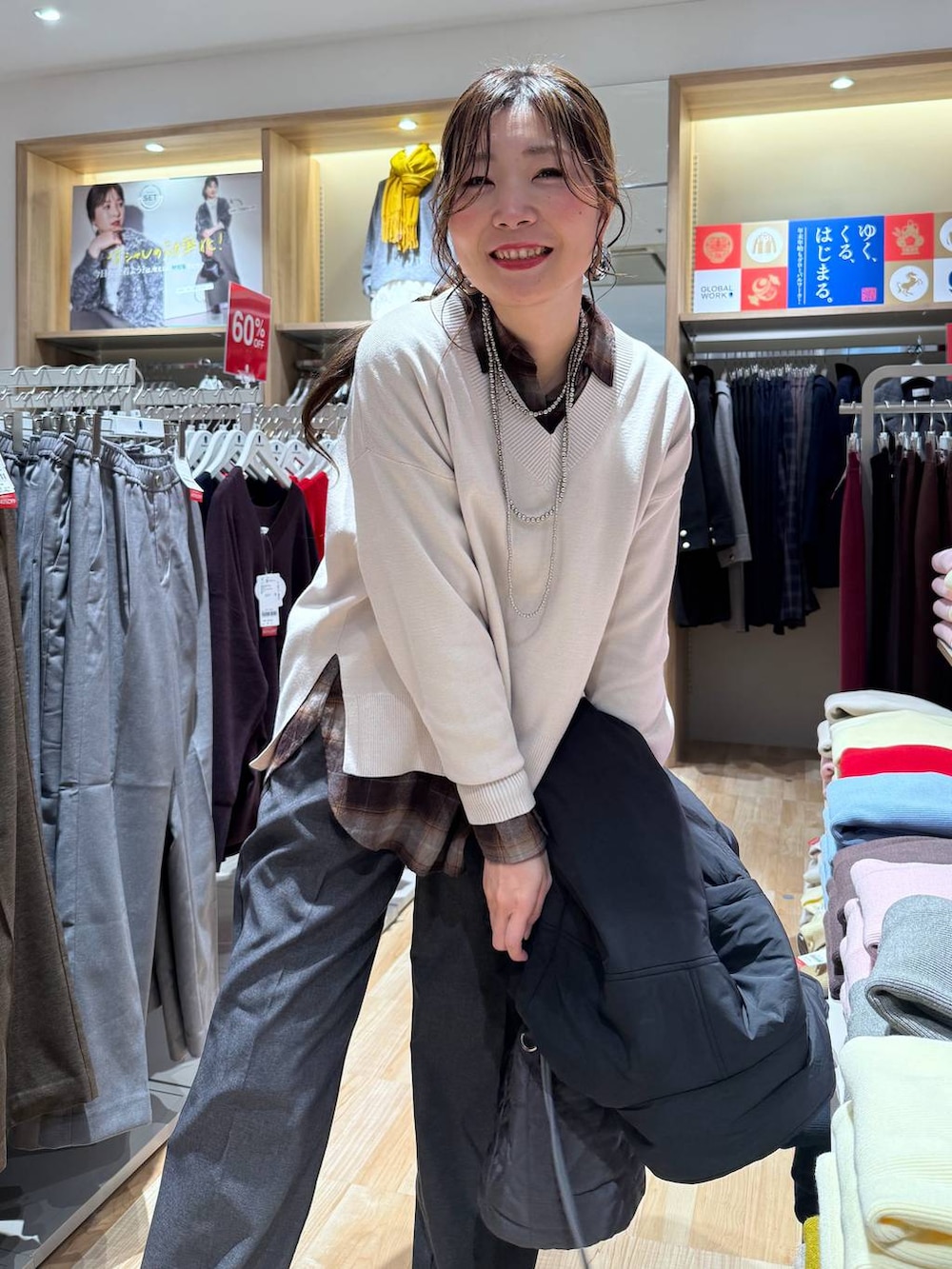 ブラック系のブルゾン、グレー系のハンドバッグ、ホワイト系のニット/セーターを着用したレディースの冬コーディネートの3枚目の写真