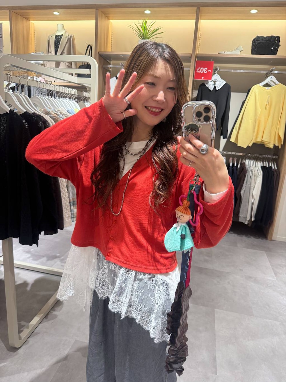ホワイト系のTシャツ/カットソー、オレンジ系のカーディガン/ボレロ、ブラック系のデニムパンツを着用したレディースの春コーディネートの3枚目の写真
