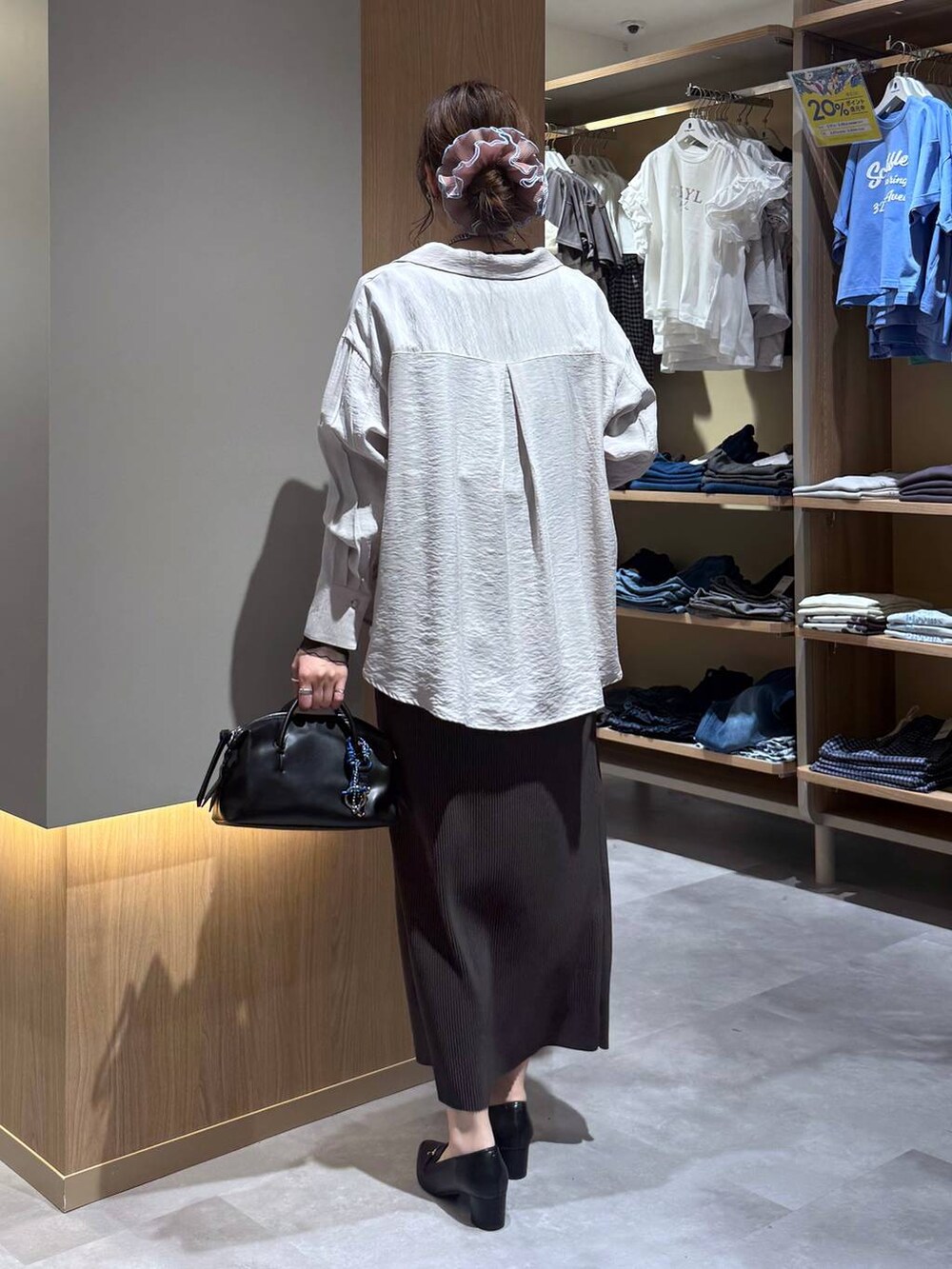 ブラック系のTシャツ/カットソー、ブラウン系のスカート、ブラック系のローファーを着用したレディースの春コーディネートの4枚目の写真