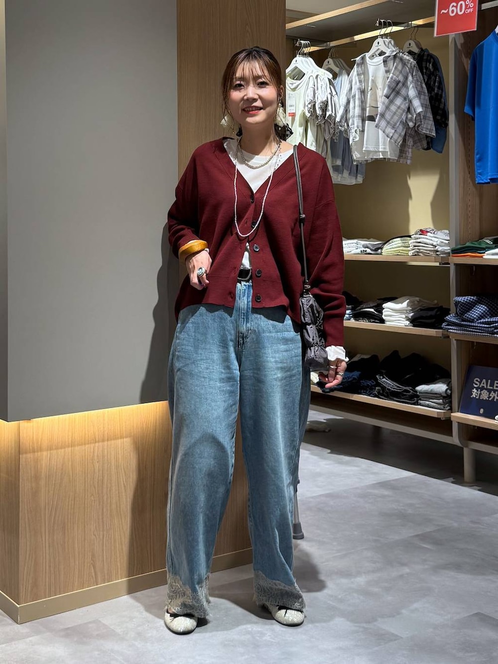 ベージュ系のTシャツ/カットソー、レッド系のカーディガン/ボレロ、グレー系のショルダーバッグを着用したレディースの秋コーディネートの2枚目の写真