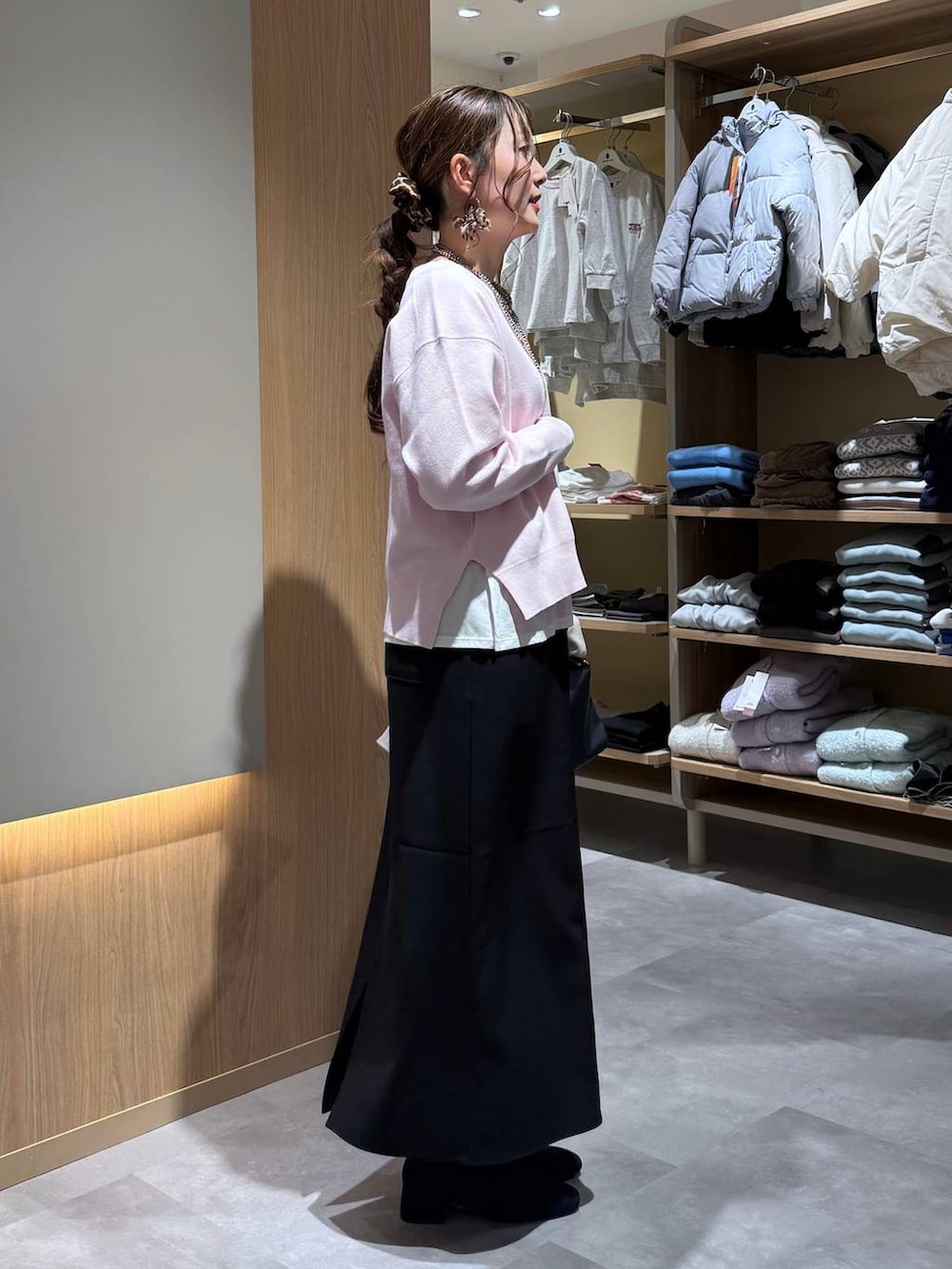 ブラック系のショルダーバッグ、ホワイト系のTシャツ/カットソー、ブラック系のブーツを着用したレディースの冬コーディネートの7枚目の写真