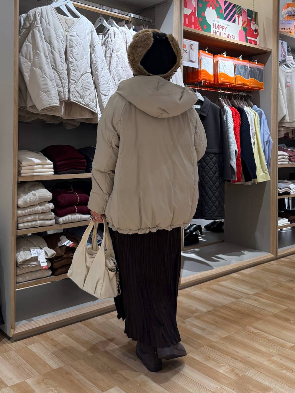 ベージュ系のダウンジャケット/コート、ホワイト系のTシャツ/カットソー、ブラウン系のスカートを着用したレディースの冬コーディネートの4枚目の写真