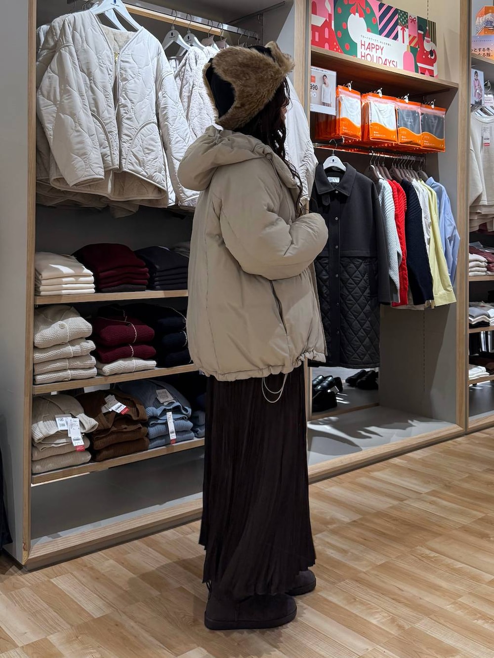 ベージュ系のダウンジャケット/コート、ホワイト系のTシャツ/カットソー、ブラウン系のスカートを着用したレディースの冬コーディネートの3枚目の写真