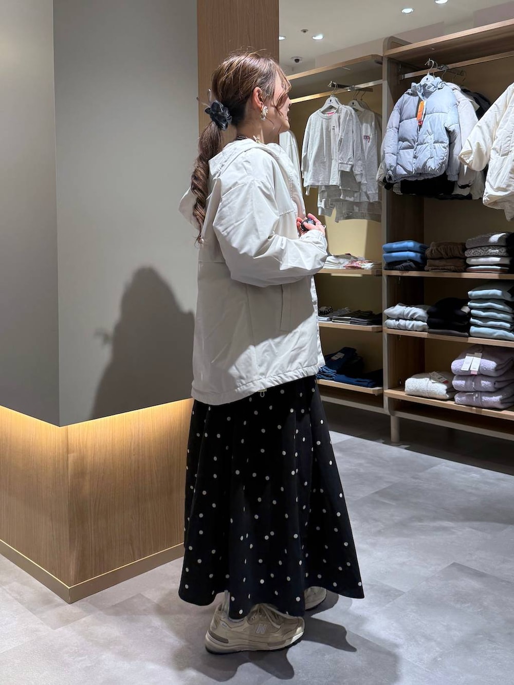 グレー系のニット/セーター、ホワイト系のスウェット、ベージュ系のマウンテンパーカーを着用したレディースの春コーディネートの3枚目の写真