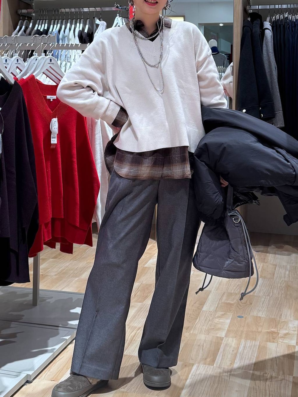 ブラック系のブルゾン、グレー系のハンドバッグ、ホワイト系のニット/セーターを着用したレディースの冬コーディネートの6枚目の写真