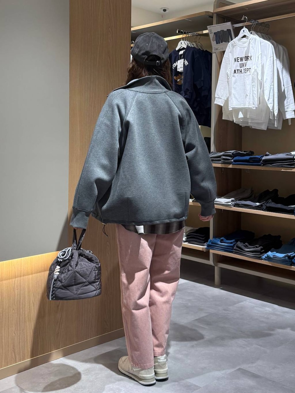 ベージュ系のニット/セーター、グレー系のハンドバッグ、ピンク系のデニムパンツを着用したレディースの春コーディネートの8枚目の写真