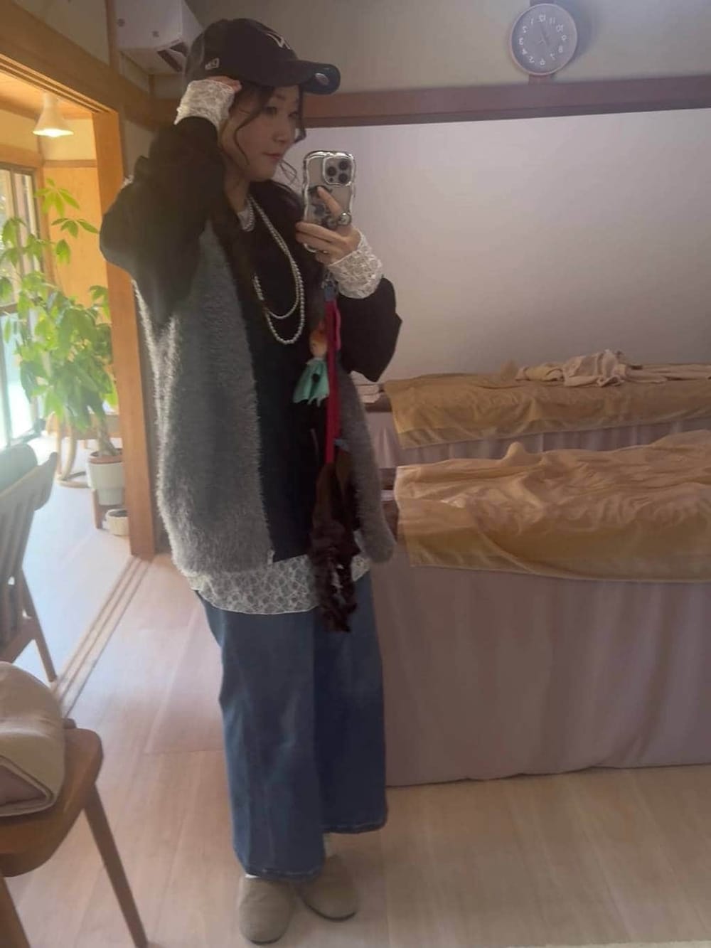 グレー系のベスト、ブルー系のデニムパンツ、ブラック系のTシャツ/カットソーを着用したレディースの春コーディネートの3枚目の写真