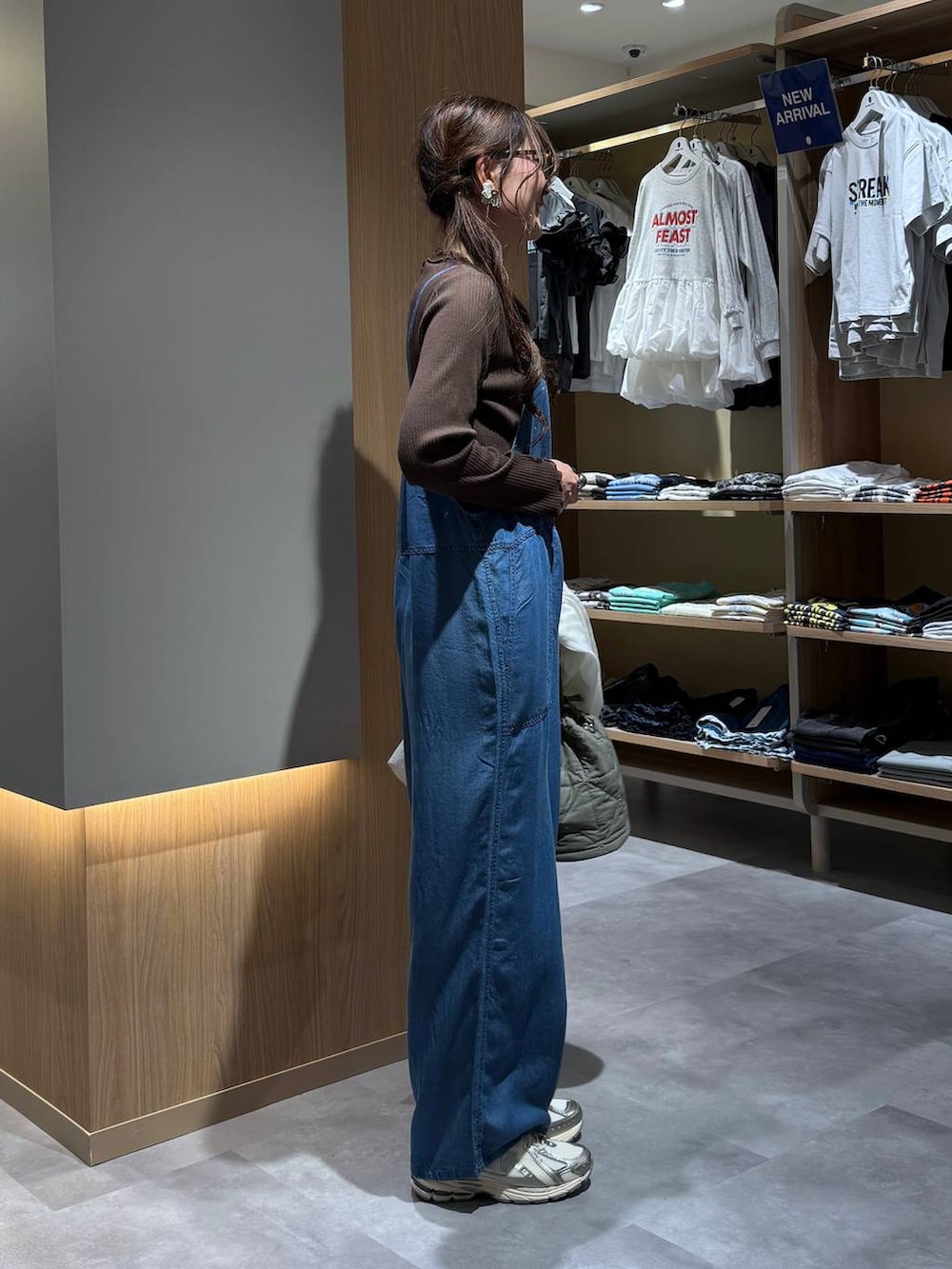 グリーン系のハンドバッグ、ホワイト系のシャツ/ブラウス、ブルー系のサロペット/オーバーオールを着用したレディースの春コーディネートの7枚目の写真