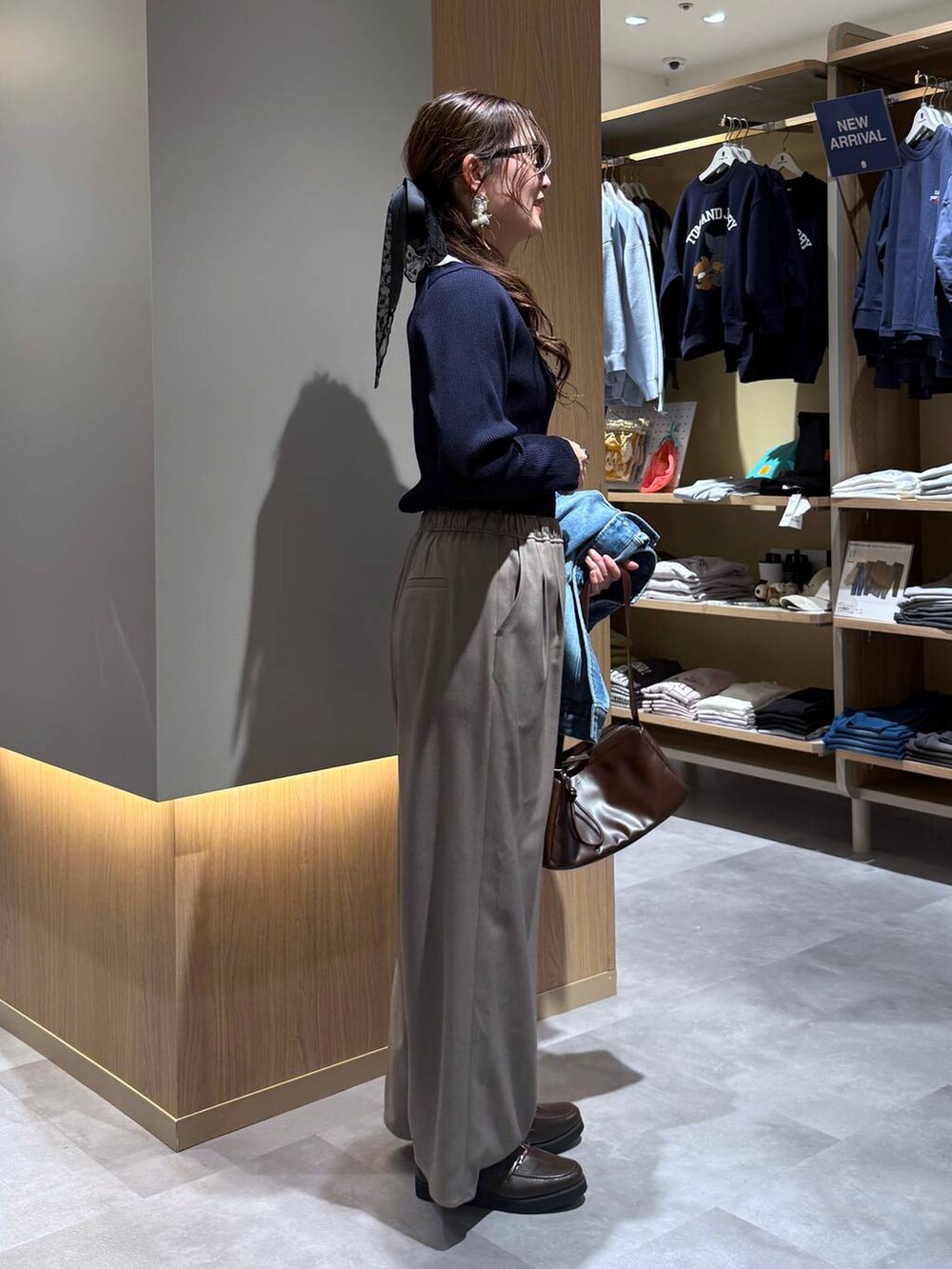 ブルー系のデニムジャケット、ブルー系のニット/セーター、ブラウン系のその他パンツを着用したレディースの春コーディネートの7枚目の写真