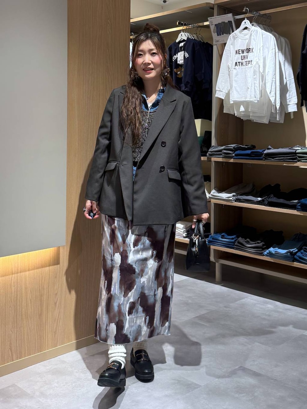 ブラック系のショルダーバッグ、ブラック系のローファー、ブルー系のシャツ/ブラウスを着用したレディースの春コーディネートの2枚目の写真