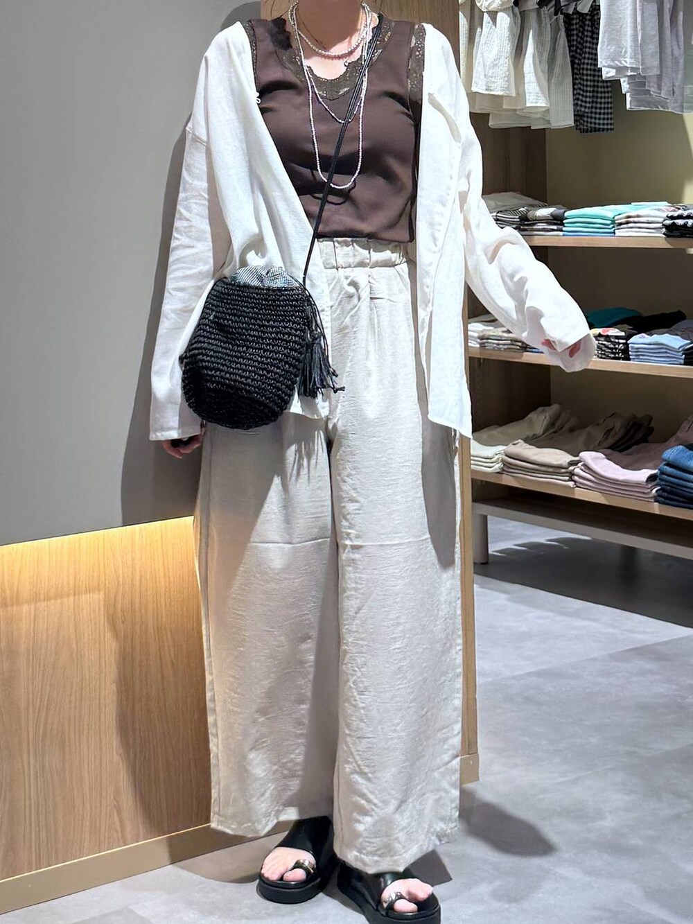 ベージュ系のその他パンツ、ホワイト系のカーディガン/ボレロ、シルバー系のネックレスを着用したレディースの夏コーディネートの5枚目の写真