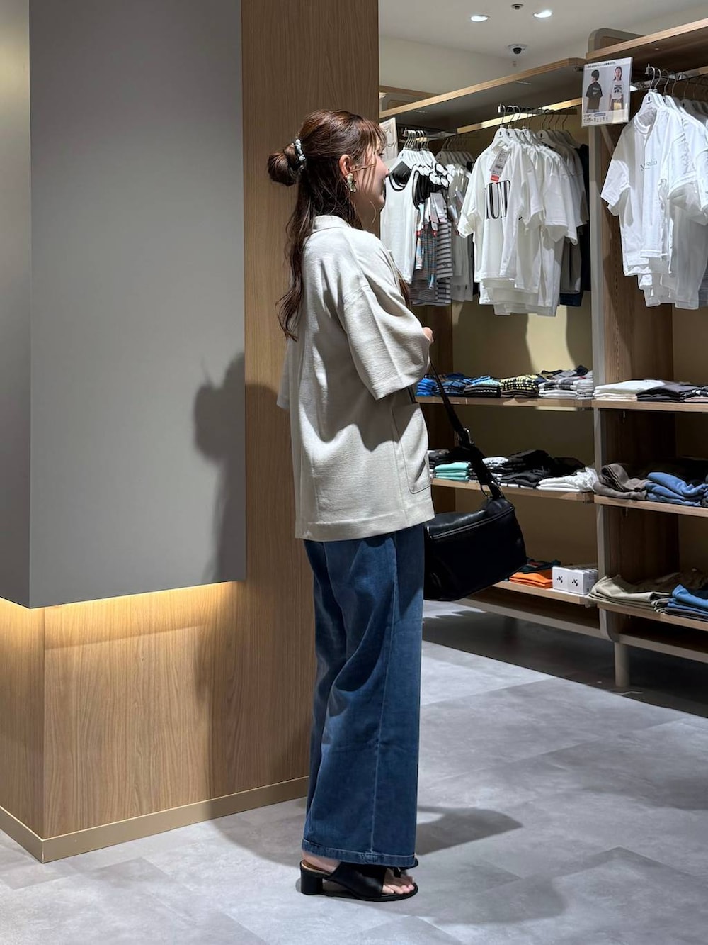 ブルー系のデニムパンツ、ベージュ系のテーラードジャケット、ブラック系のサンダルを着用したレディースの夏コーディネートの3枚目の写真