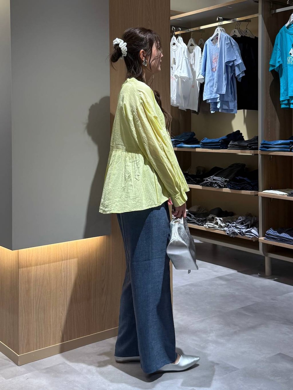 シルバー系のショルダーバッグ、シルバー系のパンプス、ホワイト系のタンクトップを着用したレディースの秋コーディネートの3枚目の写真