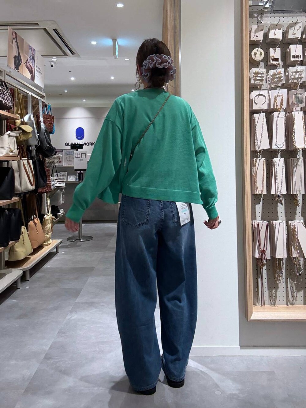 ブルー系のデニムパンツ、グリーン系のカーディガン/ボレロ、ベージュ系のボディバッグ/ウエストポーチを着用したレディースの夏コーディネートの8枚目の写真