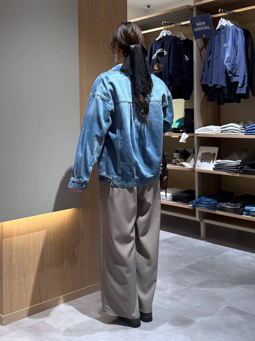 ブルー系のデニムジャケット、ブルー系のニット/セーター、ブラウン系のその他パンツを着用したレディースの春コーディネートの4枚目の写真