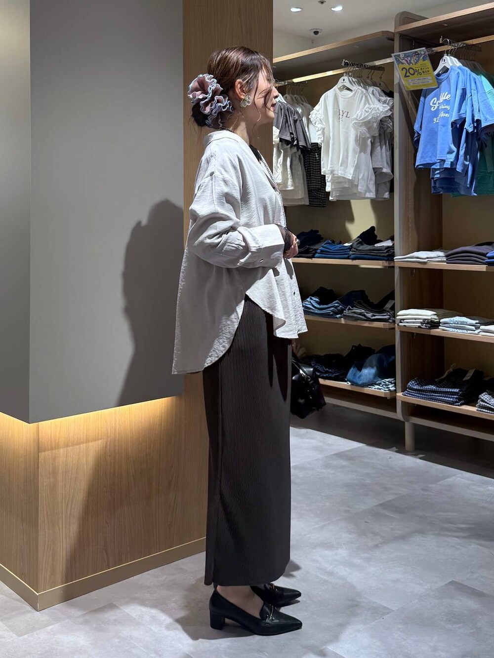 ブラック系のTシャツ/カットソー、ブラウン系のスカート、ブラック系のローファーを着用したレディースの春コーディネートの3枚目の写真