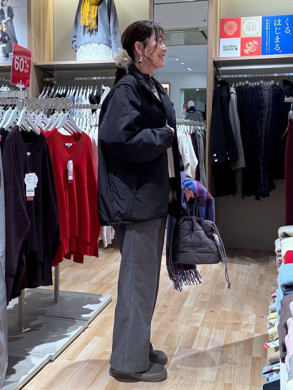 ブラック系のブルゾン、グレー系のハンドバッグ、ホワイト系のニット/セーターを着用したレディースの冬コーディネートの9枚目の写真