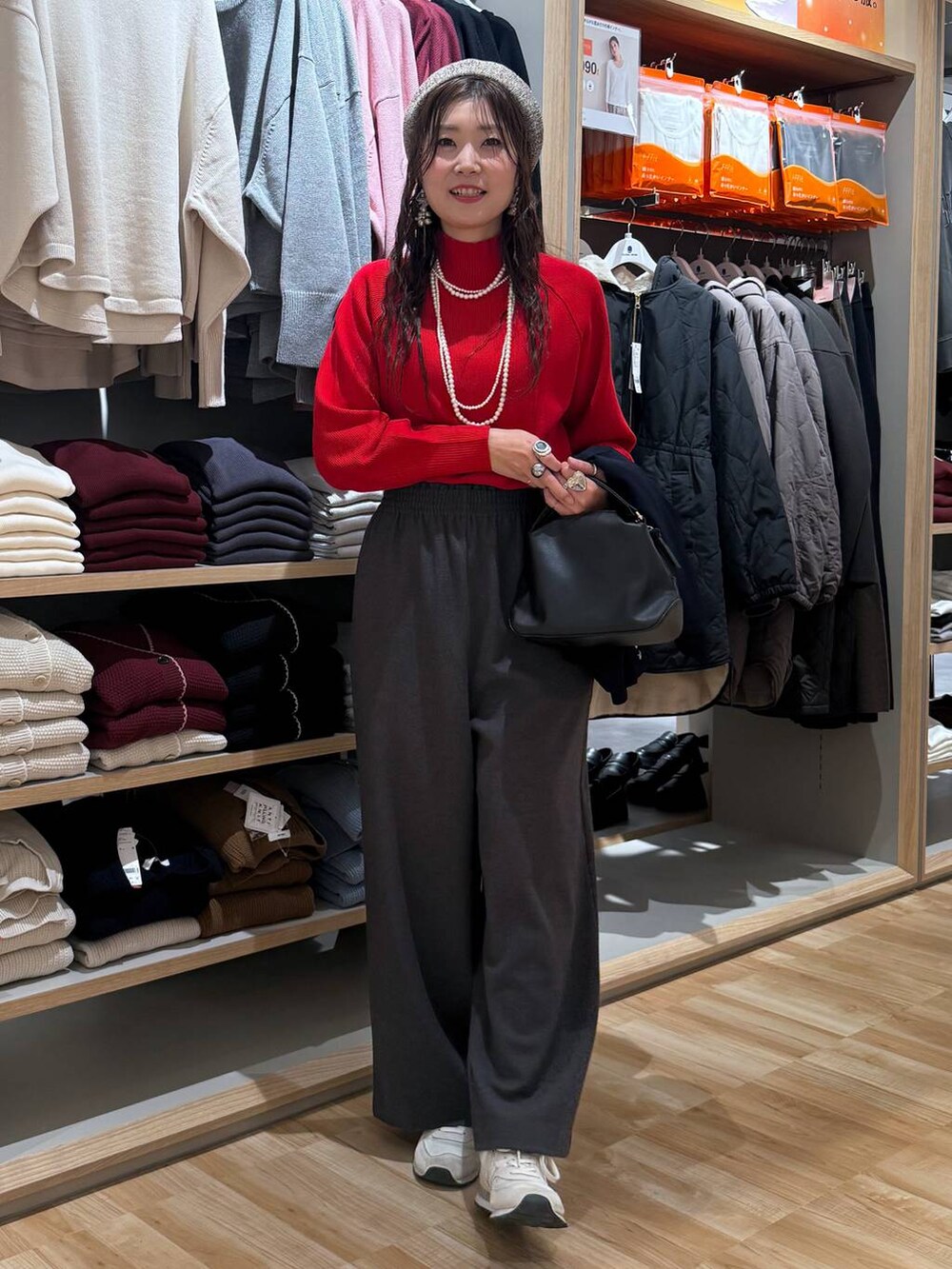 ブラック系のショルダーバッグ、レッド系のニット/セーター、ブルー系のテーラードジャケットを着用したレディースの冬コーディネートの6枚目の写真