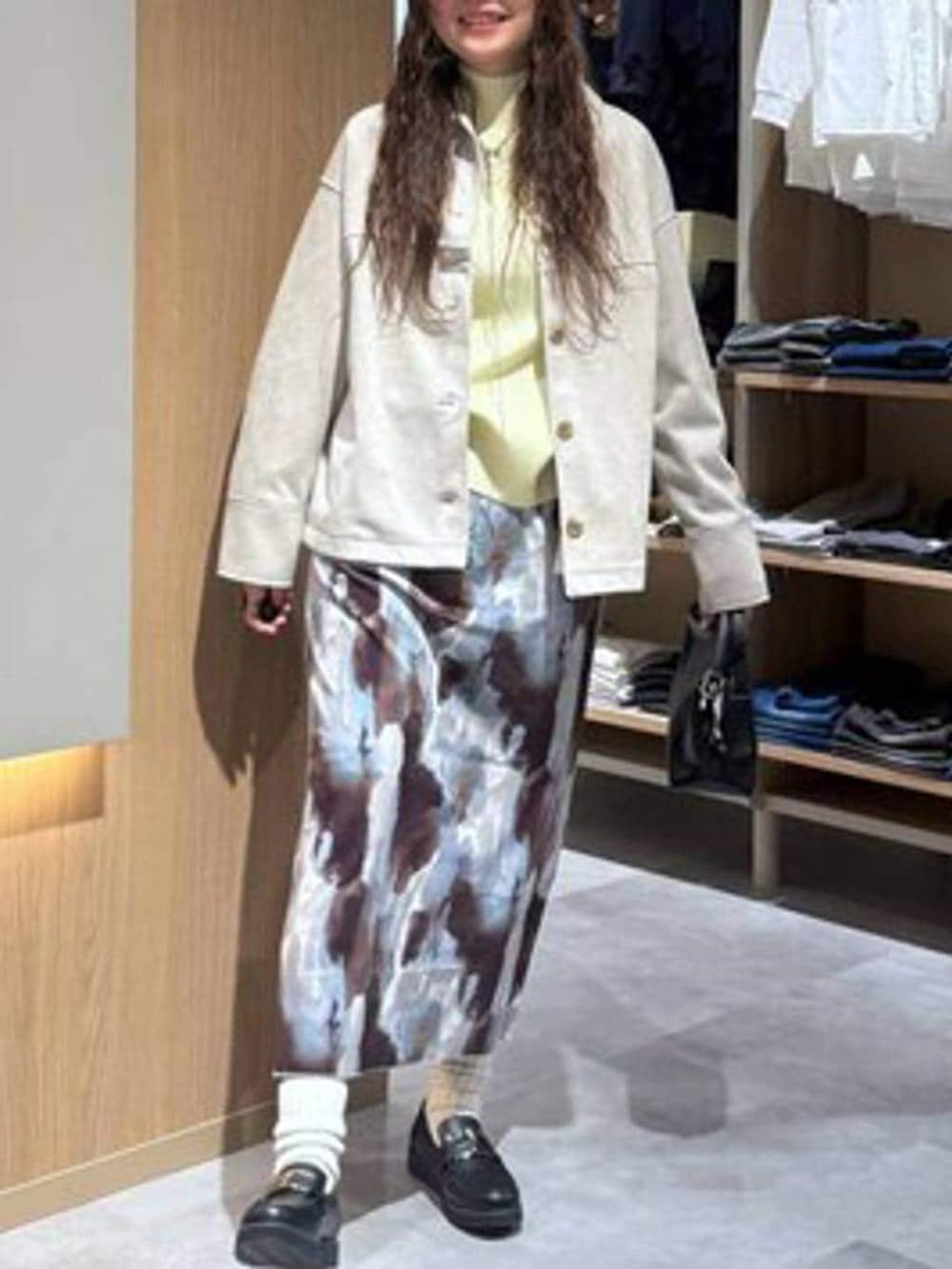 ブラック系のショルダーバッグ、ブラック系のローファー、イエロー系のニット/セーターを着用したレディースの冬コーディネートの5枚目の写真