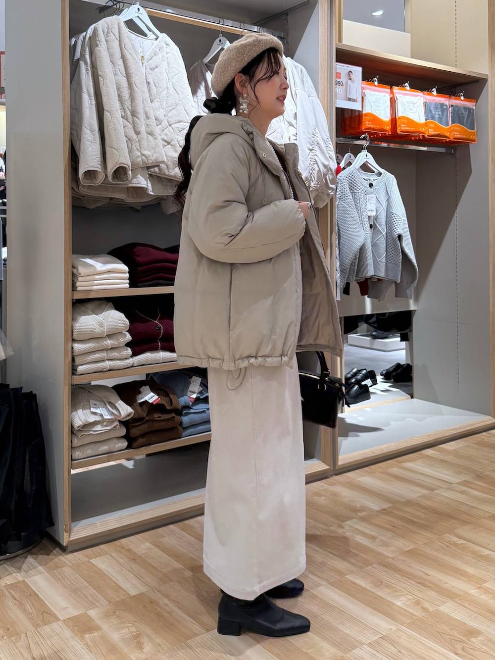 ベージュ系のダウンジャケット/コート、ブラウン系のスウェット、グレー系のスカートを着用したレディースの冬コーディネートの3枚目の写真