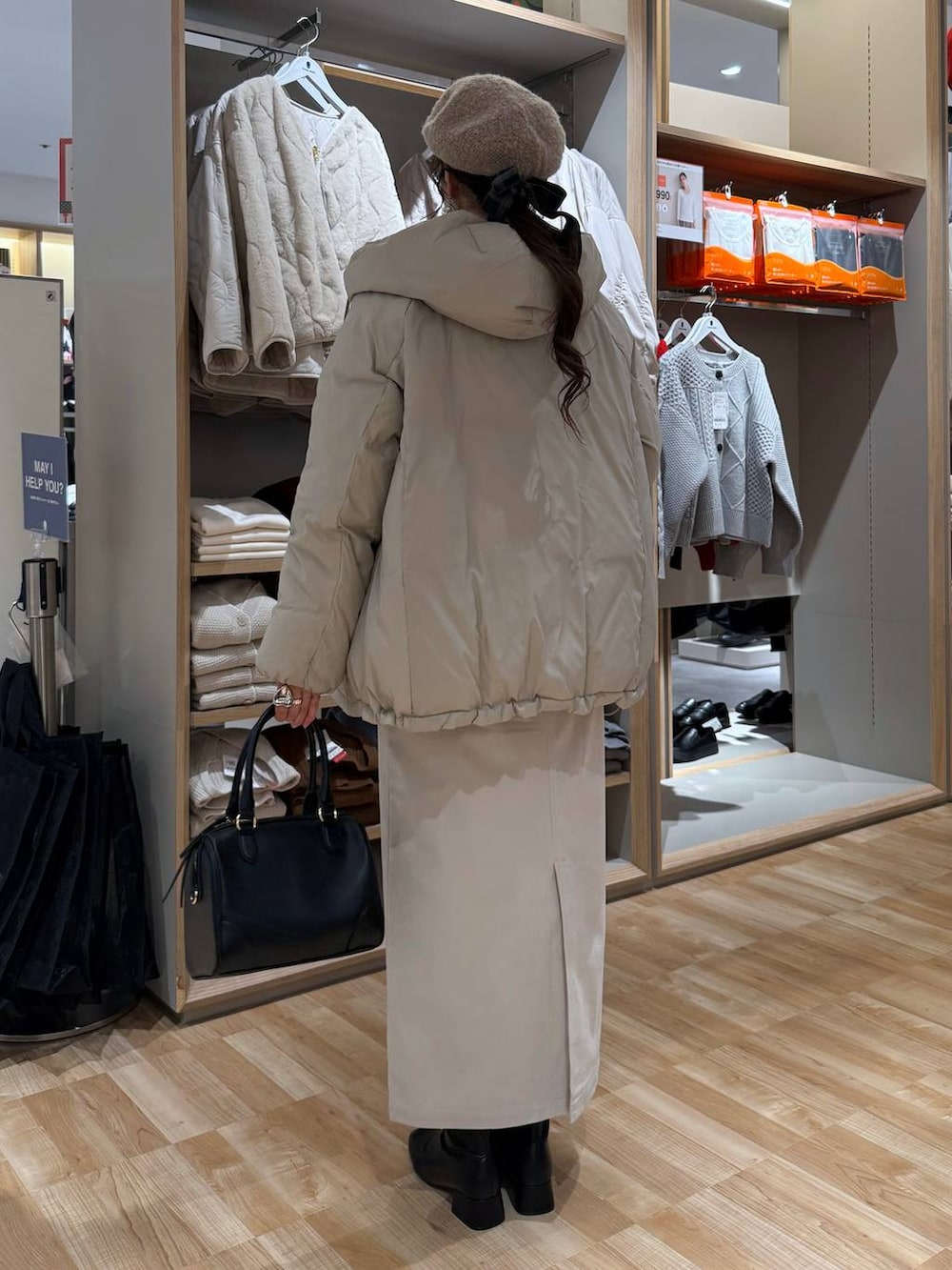 ベージュ系のダウンジャケット/コート、ブラウン系のスウェット、グレー系のスカートを着用したレディースの冬コーディネートの4枚目の写真