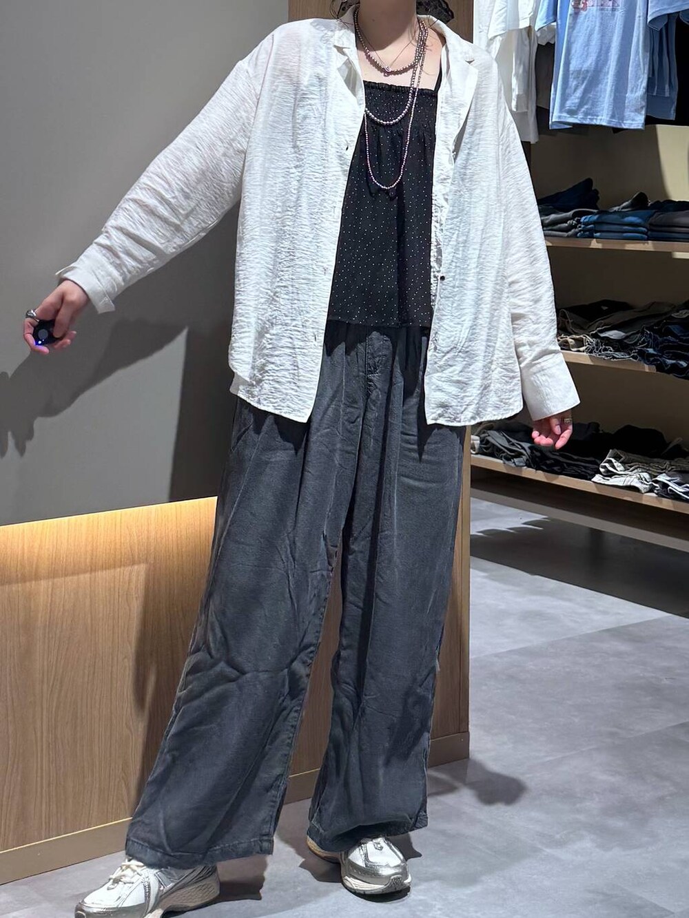ベージュ系のパーカー、ブラック系のデニムパンツ、ホワイト系のシャツ/ブラウスを着用したレディースの春コーディネートの5枚目の写真