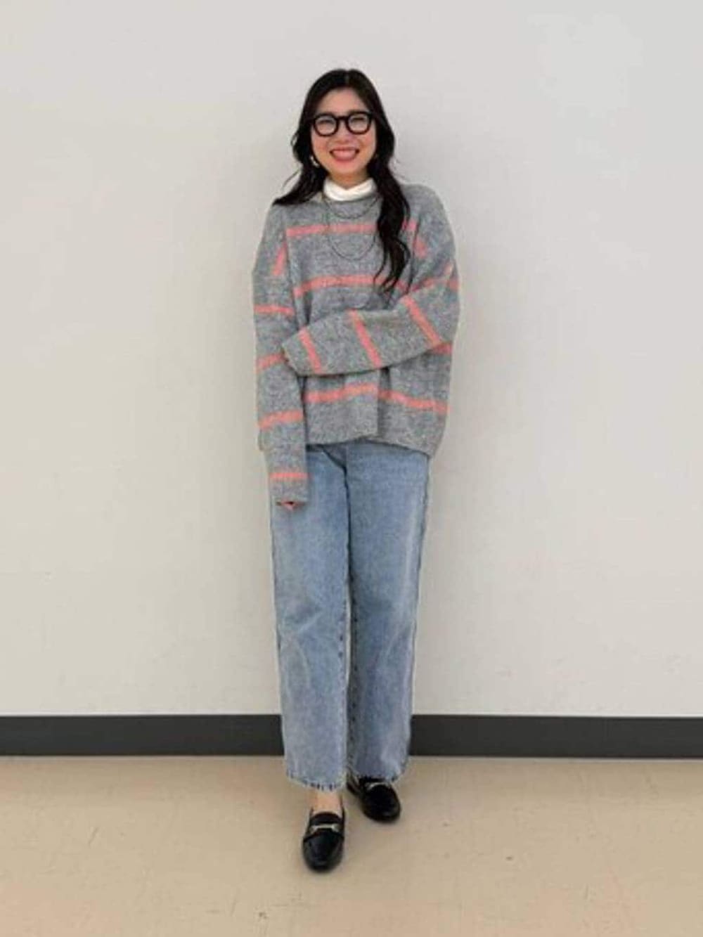 ブラック系のローファー、ブルー系のデニムパンツ、ホワイト系のTシャツ/カットソーを着用したレディースの冬コーディネートの2枚目の写真