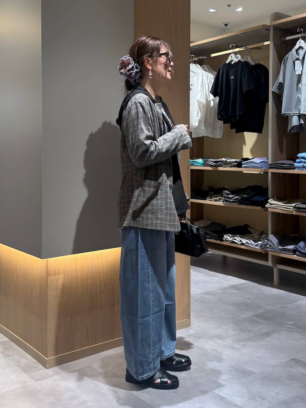 ブルー系のデニムパンツ、グレー系のテーラードジャケット、ホワイト系のタンクトップを着用したレディースの夏コーディネートの7枚目の写真
